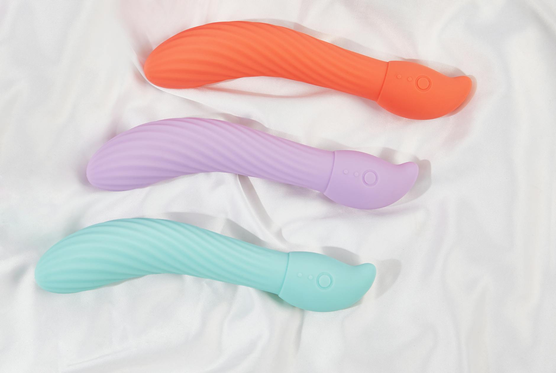 Three colorful lemon vibrators arranged on soft white fabric, symbolizing the freedom to explore pleasure without shame