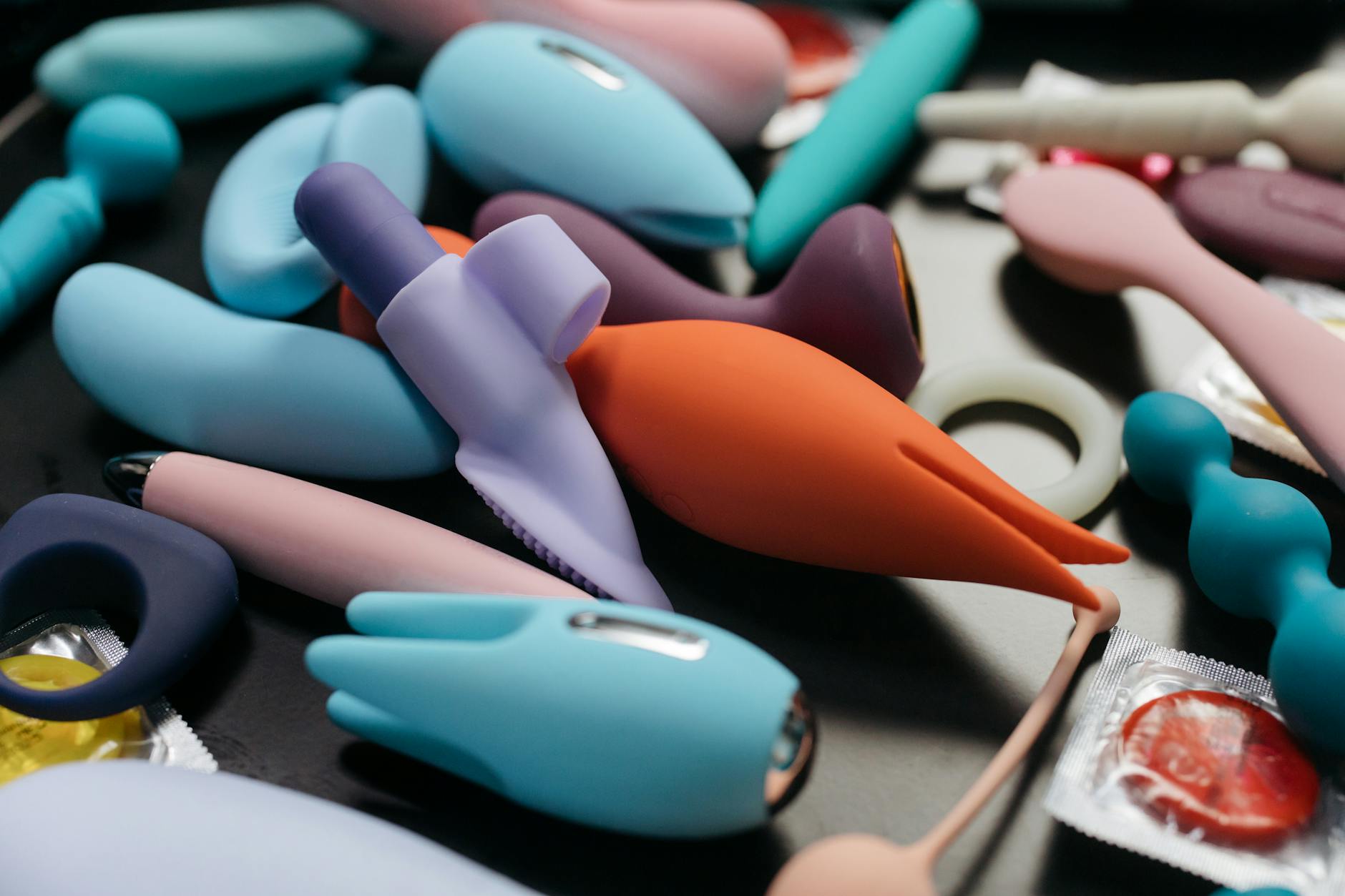 A sleek teal lemon vibrator resting on soft white silk, demonstrating the modern design of suction-based pleasure devices