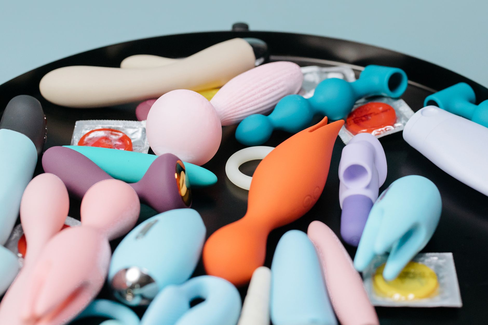 A vibrant collection of various lemon sexual toys on a black tray, featuring diverse shapes and colors for couples exploration.