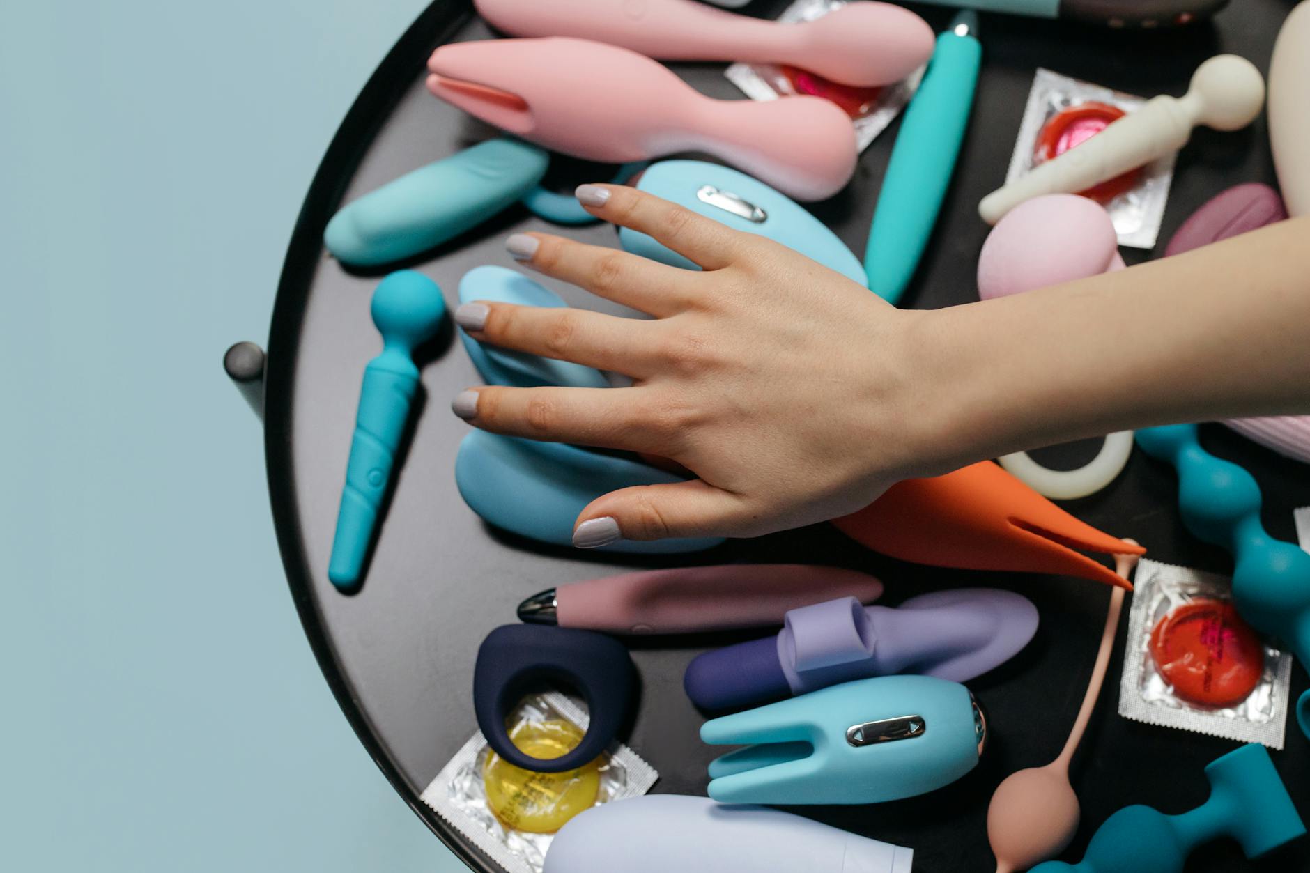 A variety of colorful vibrators arranged on a white surface