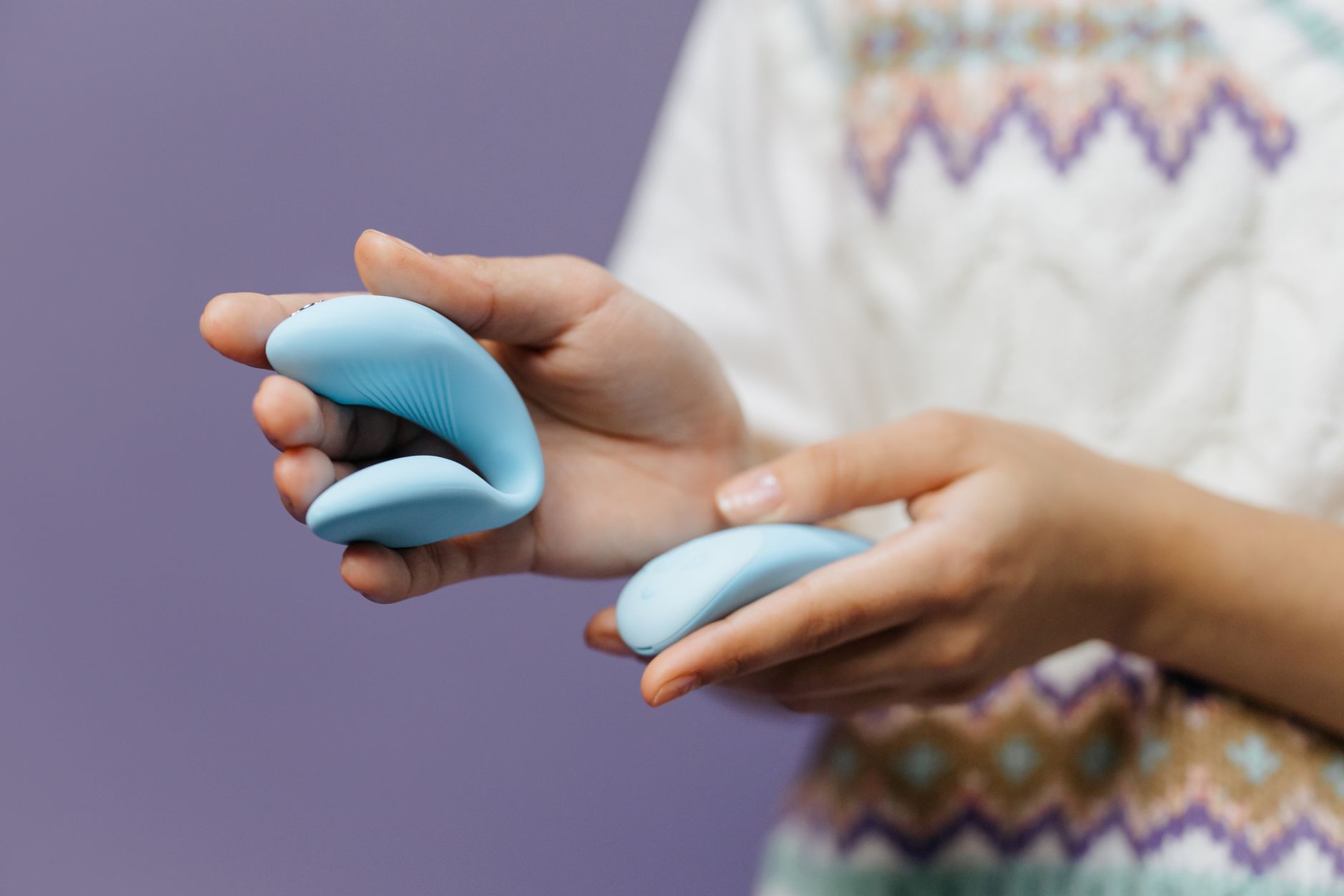 Hands holding a lemon suction vibrator against a purple background, representing reconnection with pleasure