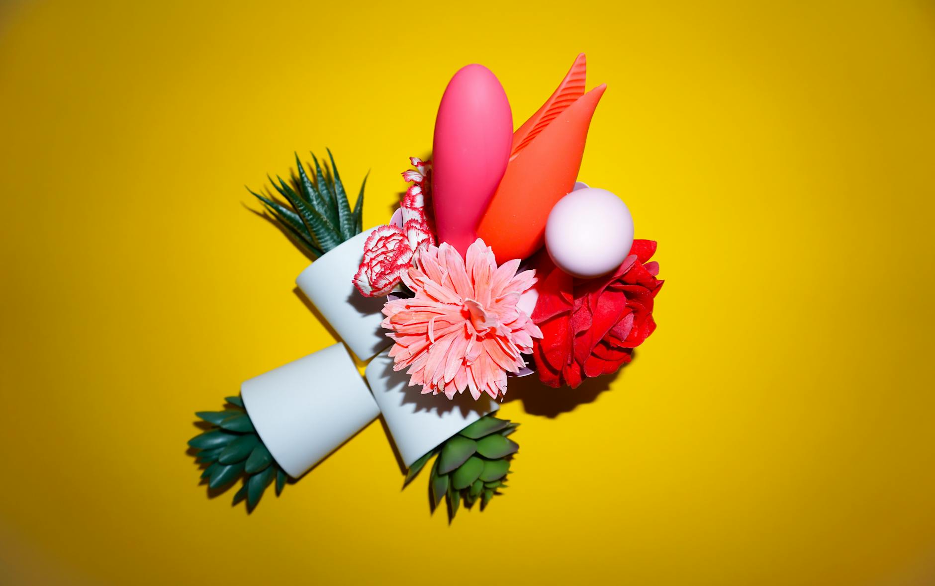 A blue lemon vibrator surrounded by flowers and citrus slices on a yellow background
