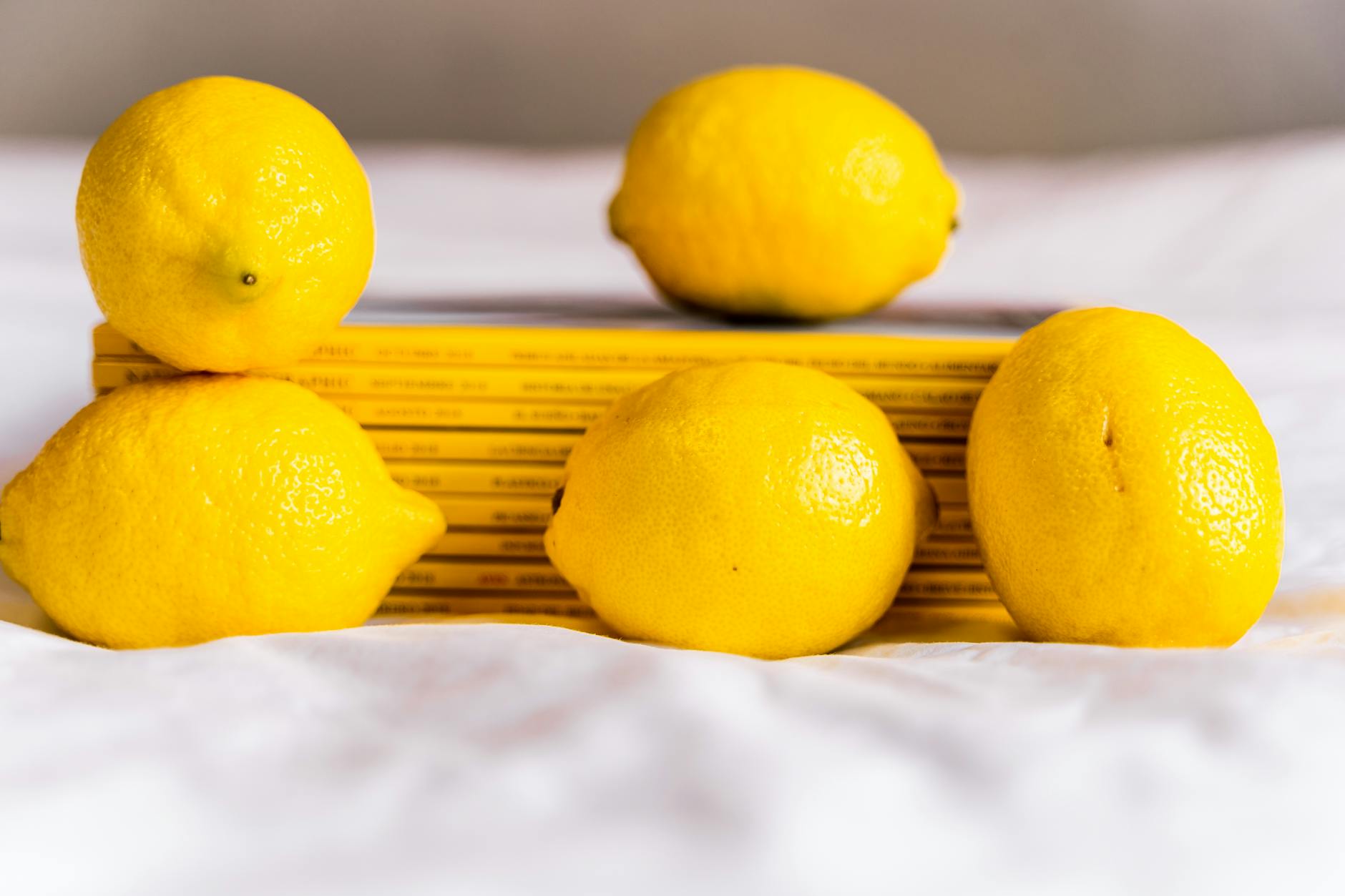 Row of bright ripe lemons with pleasant aroma on pastel background